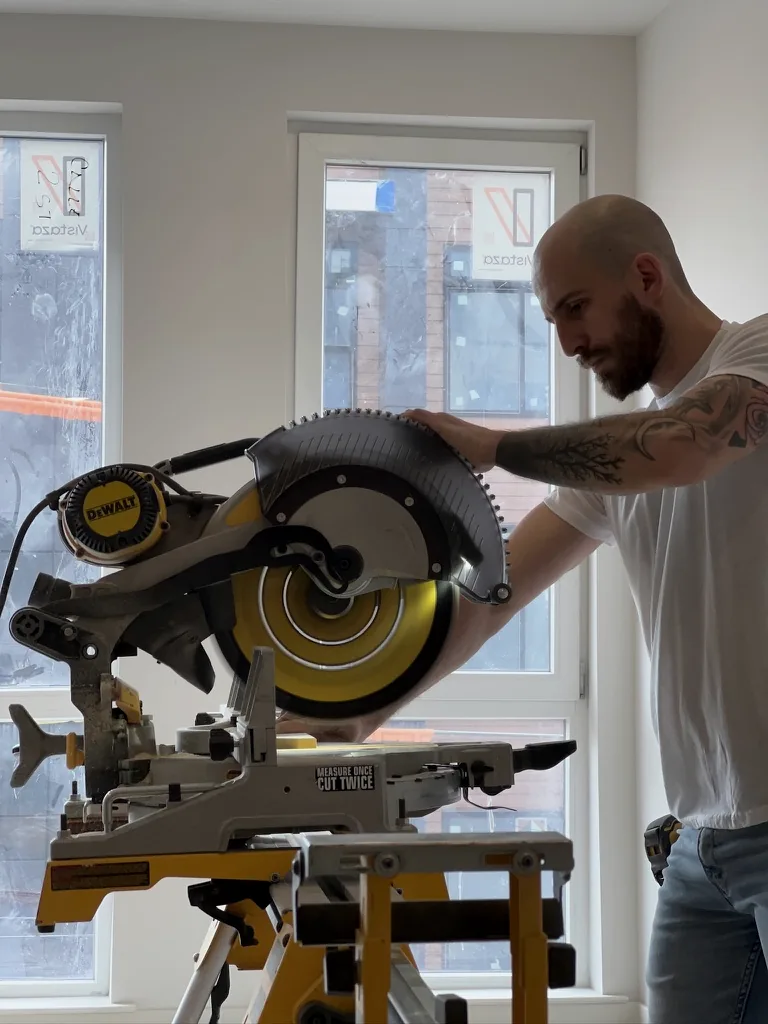 Rolan Segal, founder and finish carpenter, at work with a miter saw